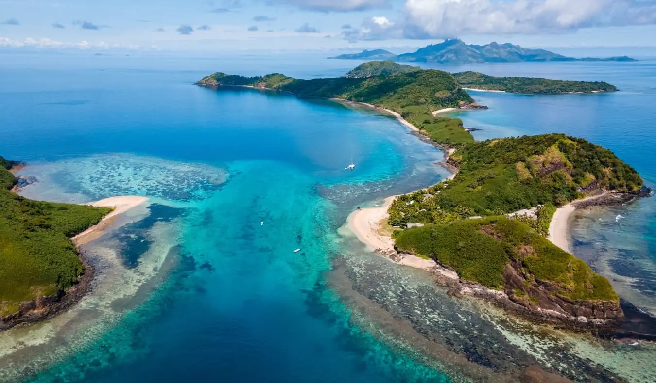 Udaljeni otoci okruženi plavom vodom na Fidžiju