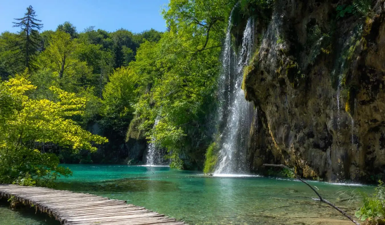 En vacker strandpromenad längs vattnet i Plitviceparken i Kroatien