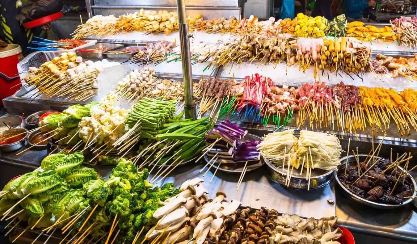 Bangkok, Tayland'daki bir sokak tezgahında ızgara üzerine dizilmiş et şişleri