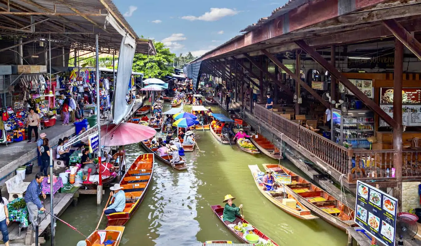 A híres úszó piac Bangkokban, Thaiföldön, ahol sok kis hajó árul a turistáknak