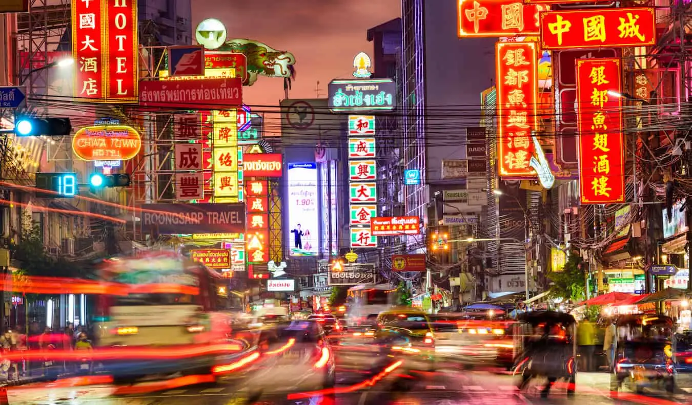 Verschwommener Verkehr und helle Lichter in Chinatown bei Nacht in Bangkok, Thailand