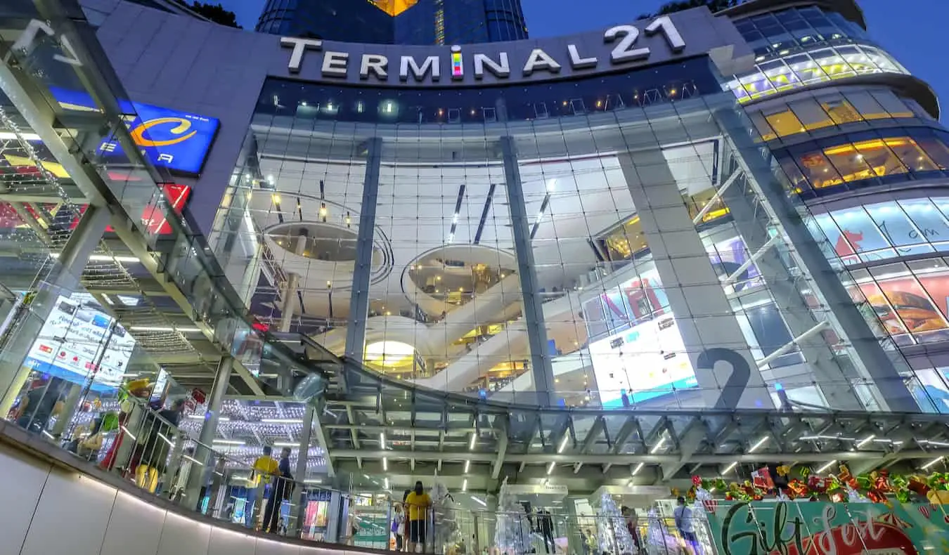 A Terminal 21 bevásárlóközpont tornyosuló külseje Bangkokban, Thaiföldön vásárló emberekkel