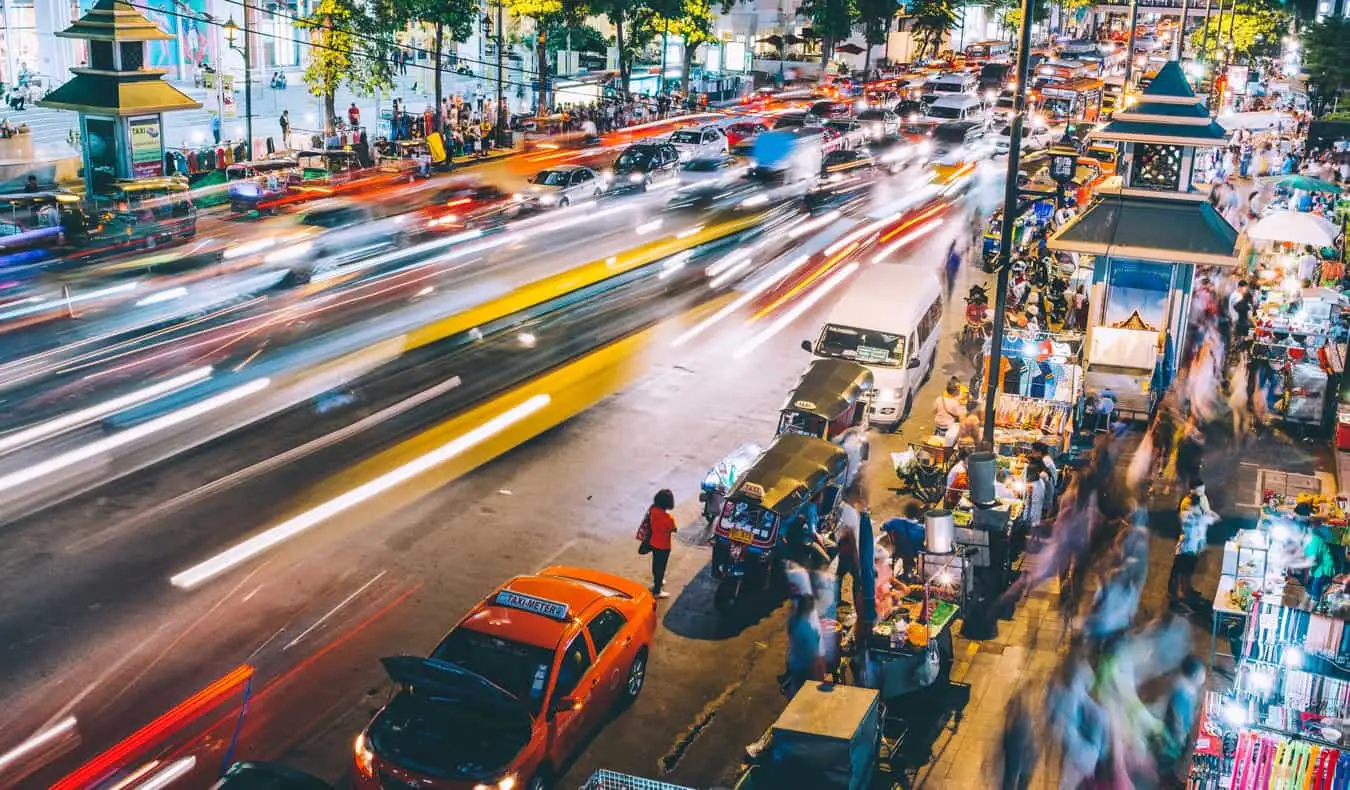 Jalan yang sibuk di Bangkokg, Thailand pada malam hari