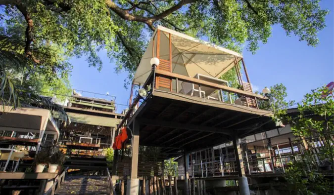 Pohled ze země při pohledu na pokoje na kovových chůdách v hostelu Tree House v Bangkoku.