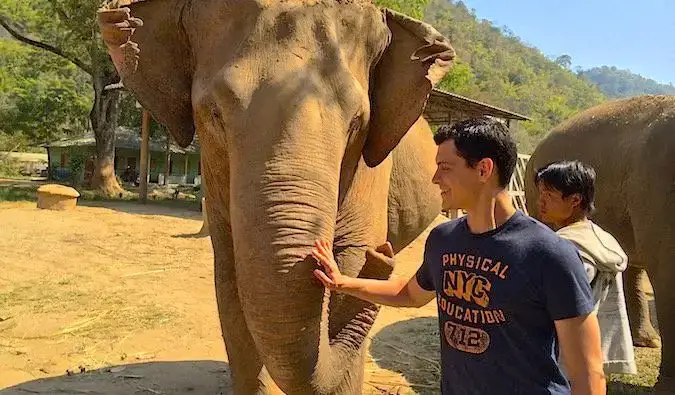 A nomád Matt Kepnes egy thai elefánttal játszik az Elephant Nature Parkban