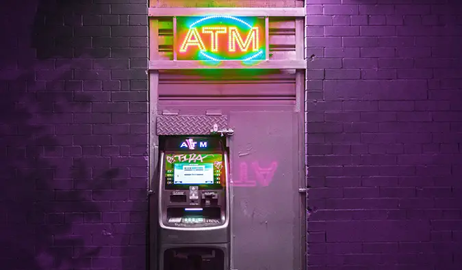 ایک ATM رات کو جامنی اینٹوں کی دیوار کے خلاف روشن تھا۔