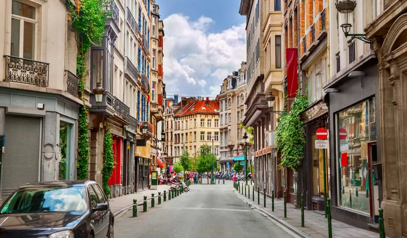 Menschen, die um den Grand Place herumlaufen, den zentralen Platz in Brüssel, Belgien, gesäumt von vergoldeten und verzierten Gebäuden