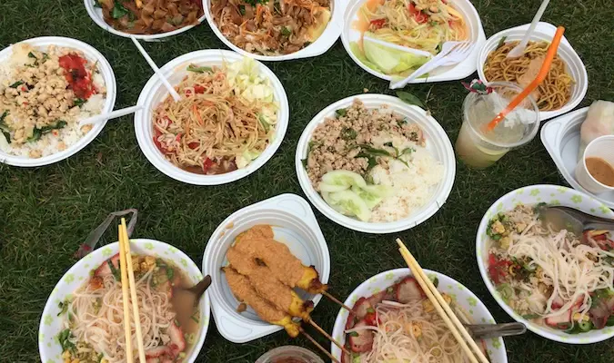 Muitos pratos de comida tailandesa para compartilhar no mercado de Berlim