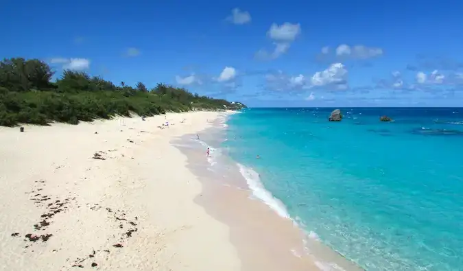 Ein langer Sandstrand und klares blaues Wasser auf Bermuda