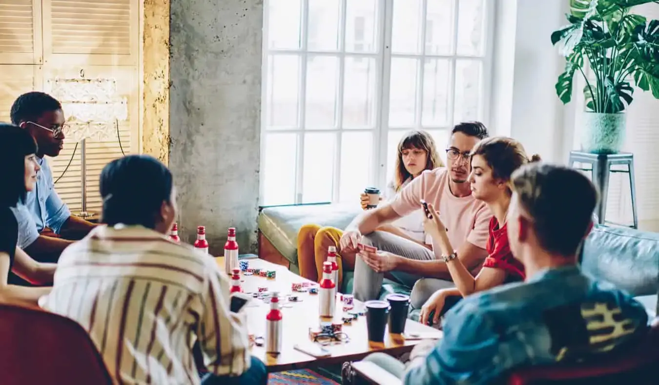 Hostelde yeni arkadaşlar birlikte oyun oynuyor ve içki içiyor