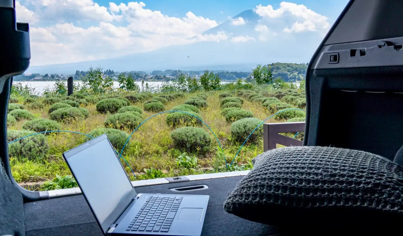 Een laptop in een busje terwijl een digitale nomade de berg Fuji in Japan bewondert