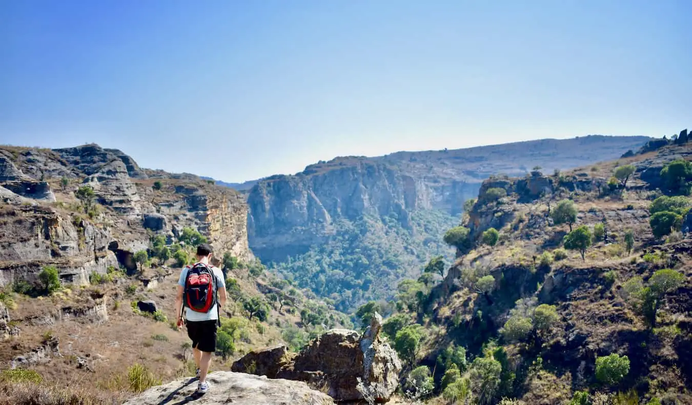 Nomadic Matt πεζοπορία σόλο στην Αφρική πάνω από έναν απόκρημνο βράχο