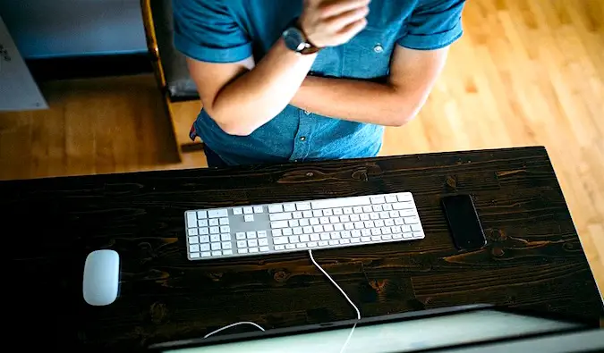 een reisblogger die aan een bureau zit en op zijn laptop werkt