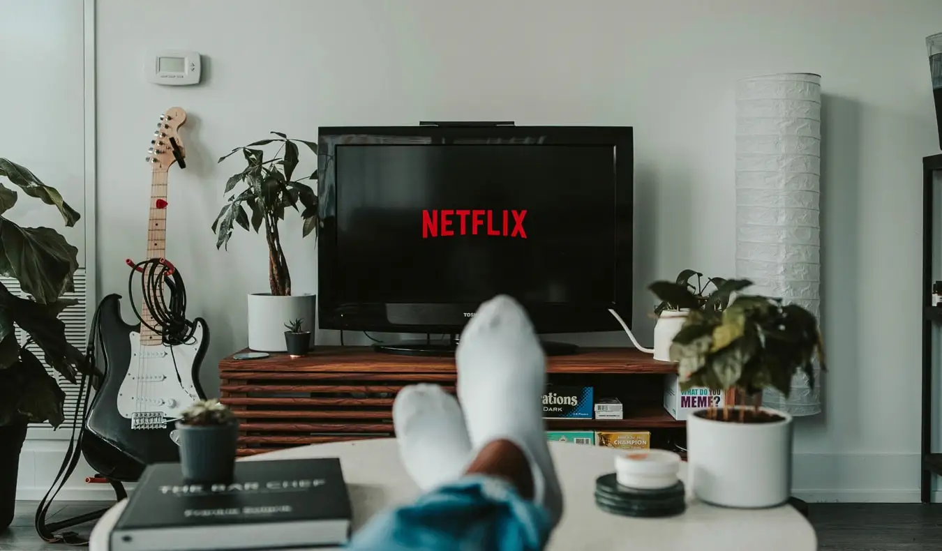 Oseba, ki sedi na kavču in gleda Netflix