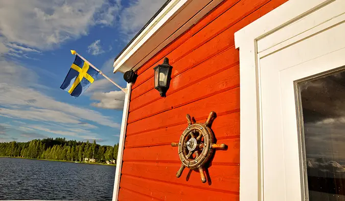 Isang tipikal na Swedish cottage na may Swedish flag sa panahon ng tag-araw sa Sweden