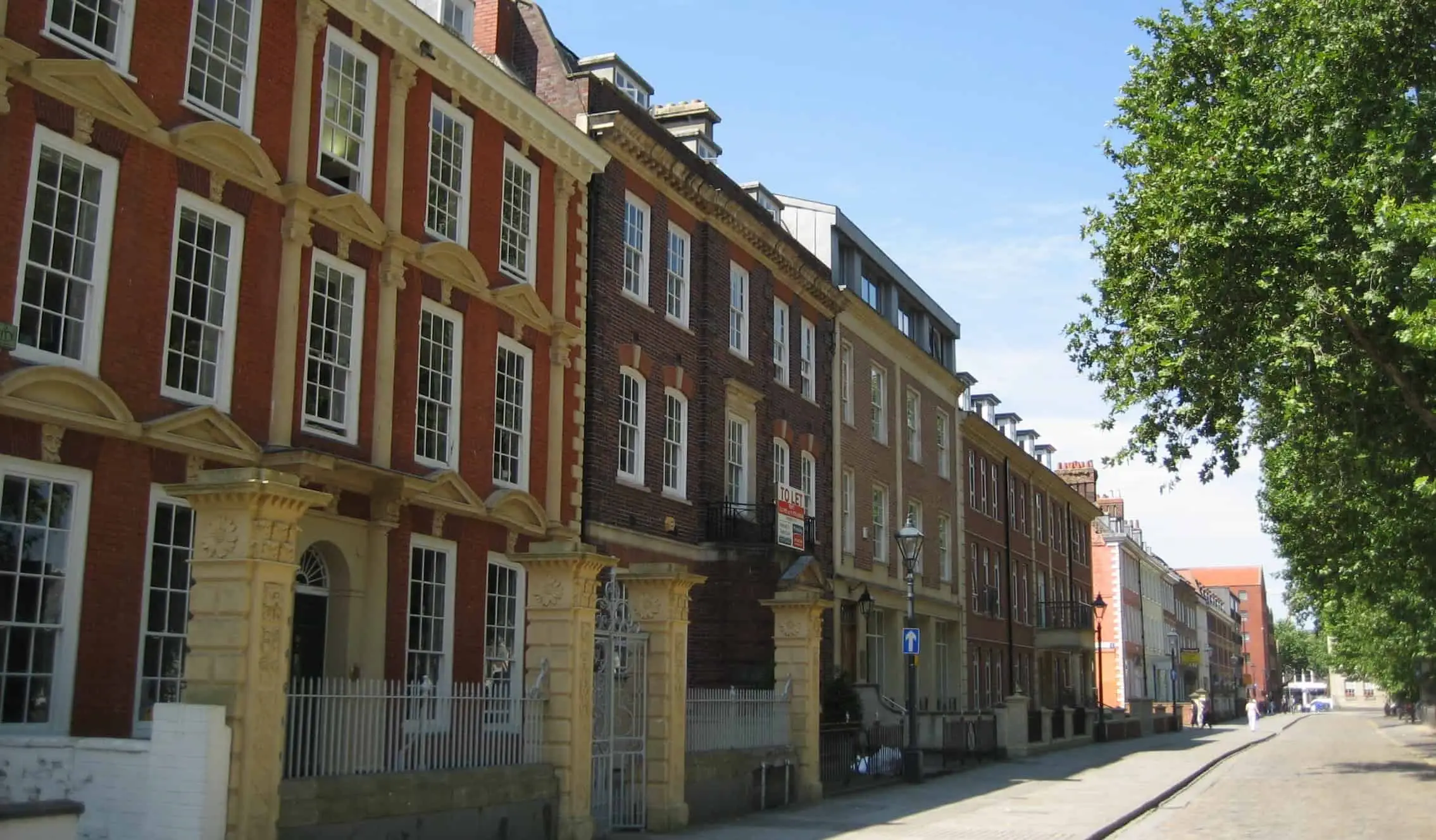 Een rij historische bakstenen herenhuizen aan een geplaveide straat in Bristol, Verenigd Koninkrijk