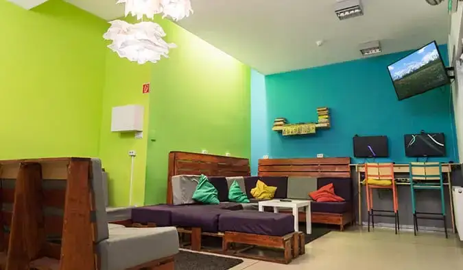 Area umum dengan sofa, TV, dan dua komputer di Hostel One, Budapest