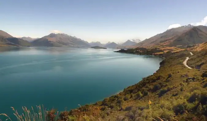 Skove og bjerge omgiver et roligt vandområde i det fantastiske New Zealand