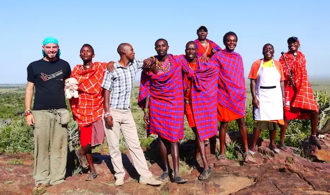 Un viajero posando con el pueblo Massai en Kenia