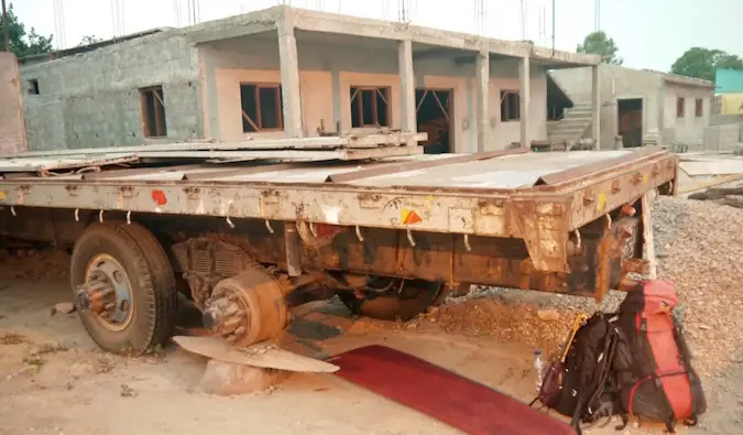 Berkemah secara kasar di tempat parkir di bawah truk semi tua di Afrika