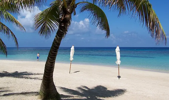 pantai tropis dengan payung dan ombak