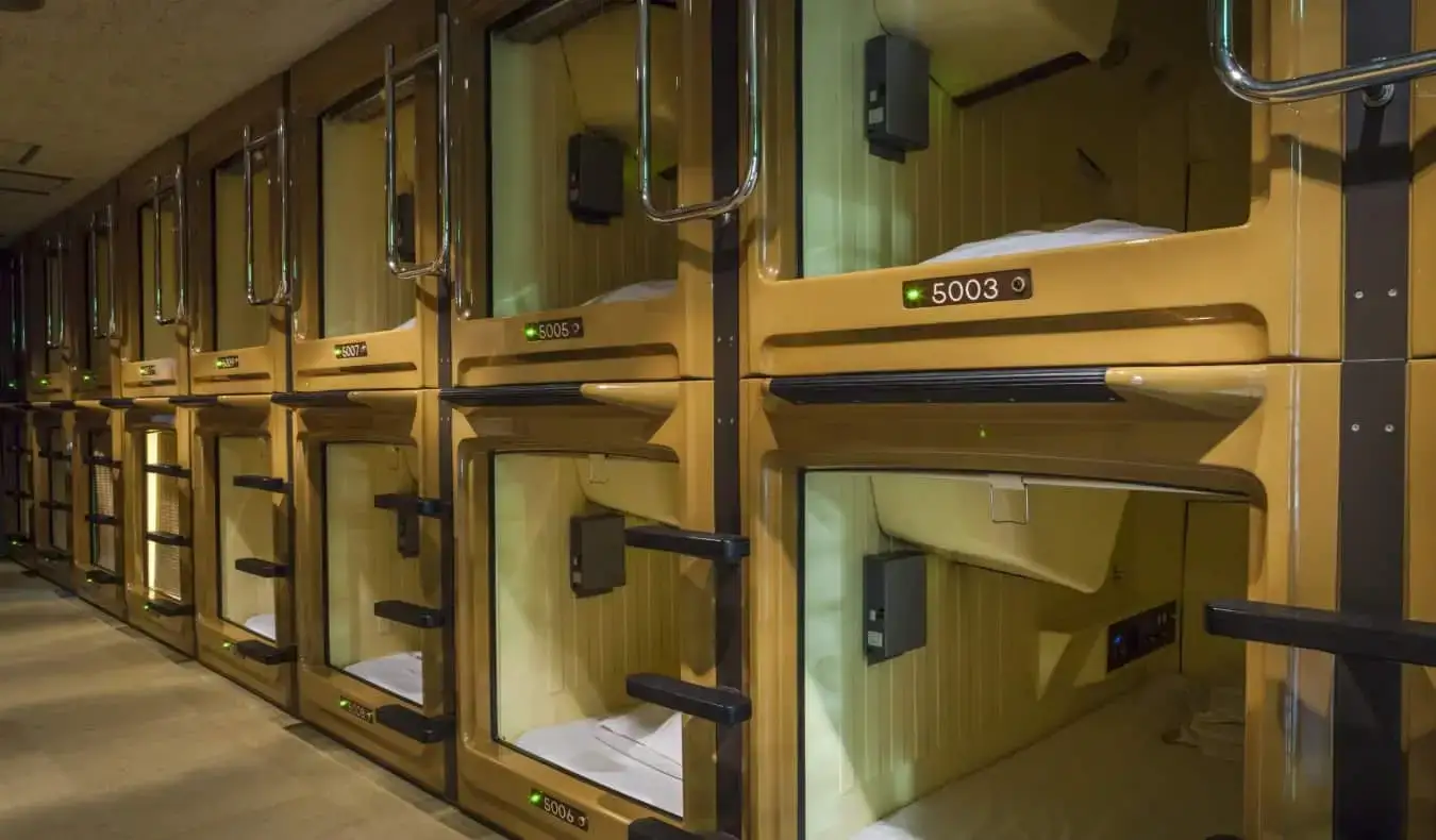 Una fila di capsule per dormire in un capsule hotel in Giappone