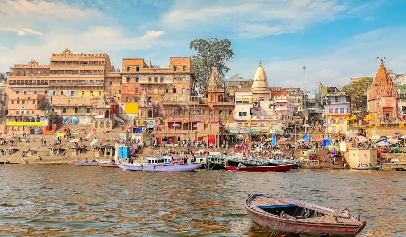 Una vista de los edificios antiguos a lo largo del famoso río Ganges en la India, con mucha gente y barcos