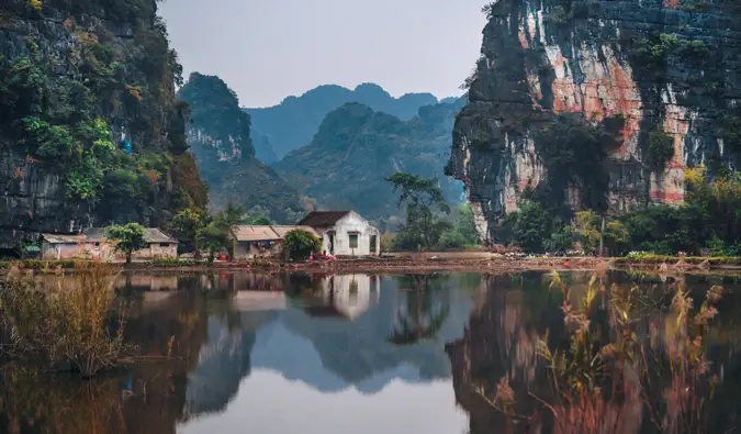 Et lille hus mellem to høje klipper i Vietnam