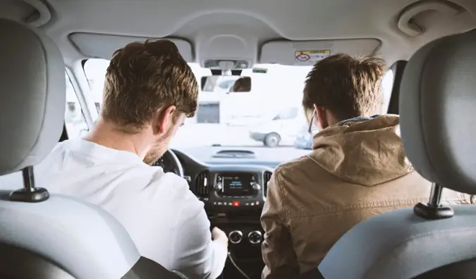 Dos amigos en un coche juntos iniciando un viaje por carretera