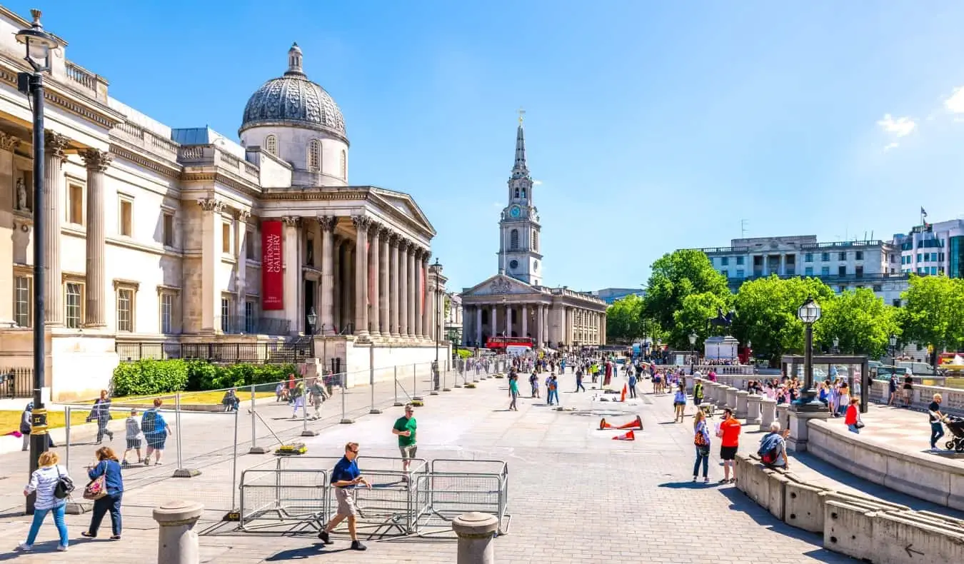 Národní galerie umění v Londýně s lidmi, kteří jdou v létě venku na Trafalgar Square