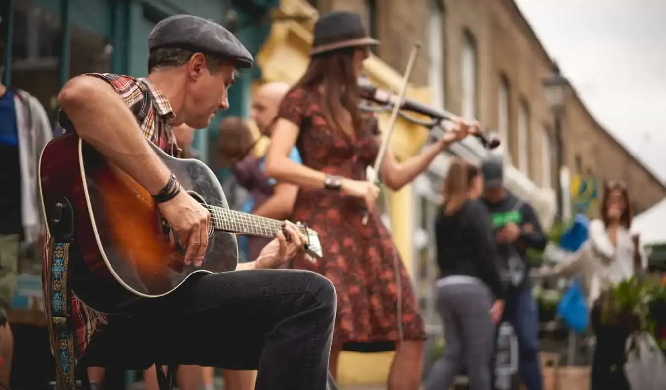 Un chitarist și un violonist cântă la Columbia Road Flower Market din Londra, Anglia