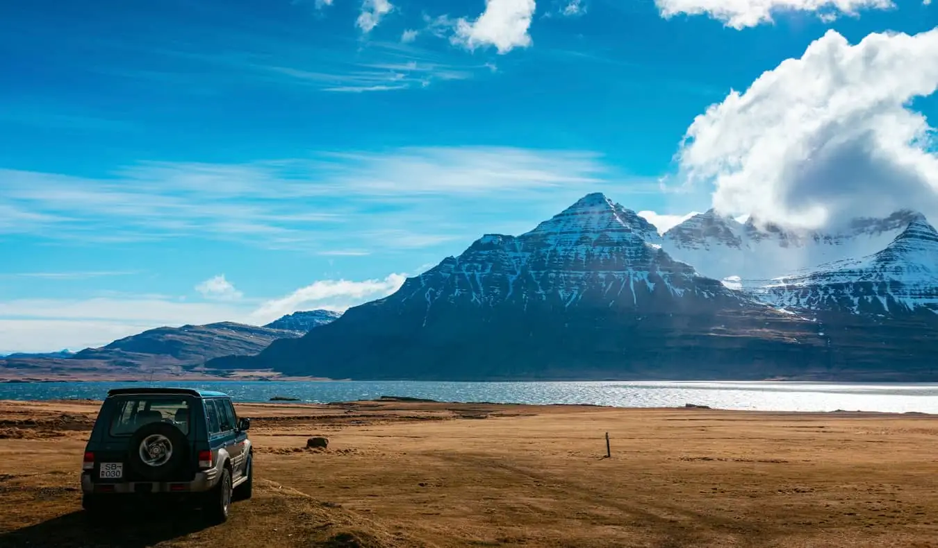 Un coche aparcado cerca de las montañas de Islandia