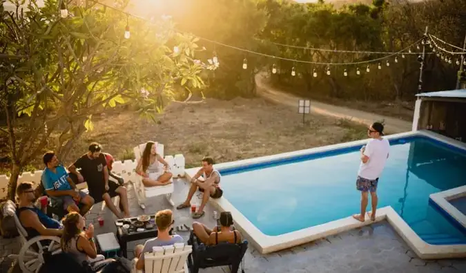 Um grupo de mochileiros relaxando na piscina de um albergue na América Central