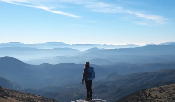 Uma viajante solitária em pé em uma montanha