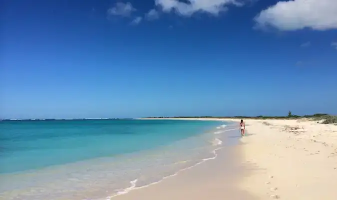 pengembara wanita berseorangan berjalan di pantai di Kepulauan Virgin