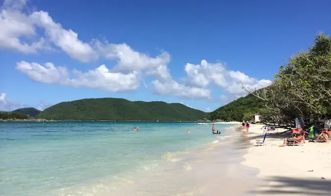 Žmonės plaukioja ir atsipalaiduoja Cinamono įlankos paplūdimyje, USVI