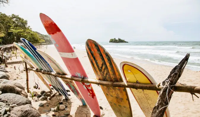 Nakahilera ang mga surfboard sa buhangin sa beach sa Puerto Viejo, Costa Rica