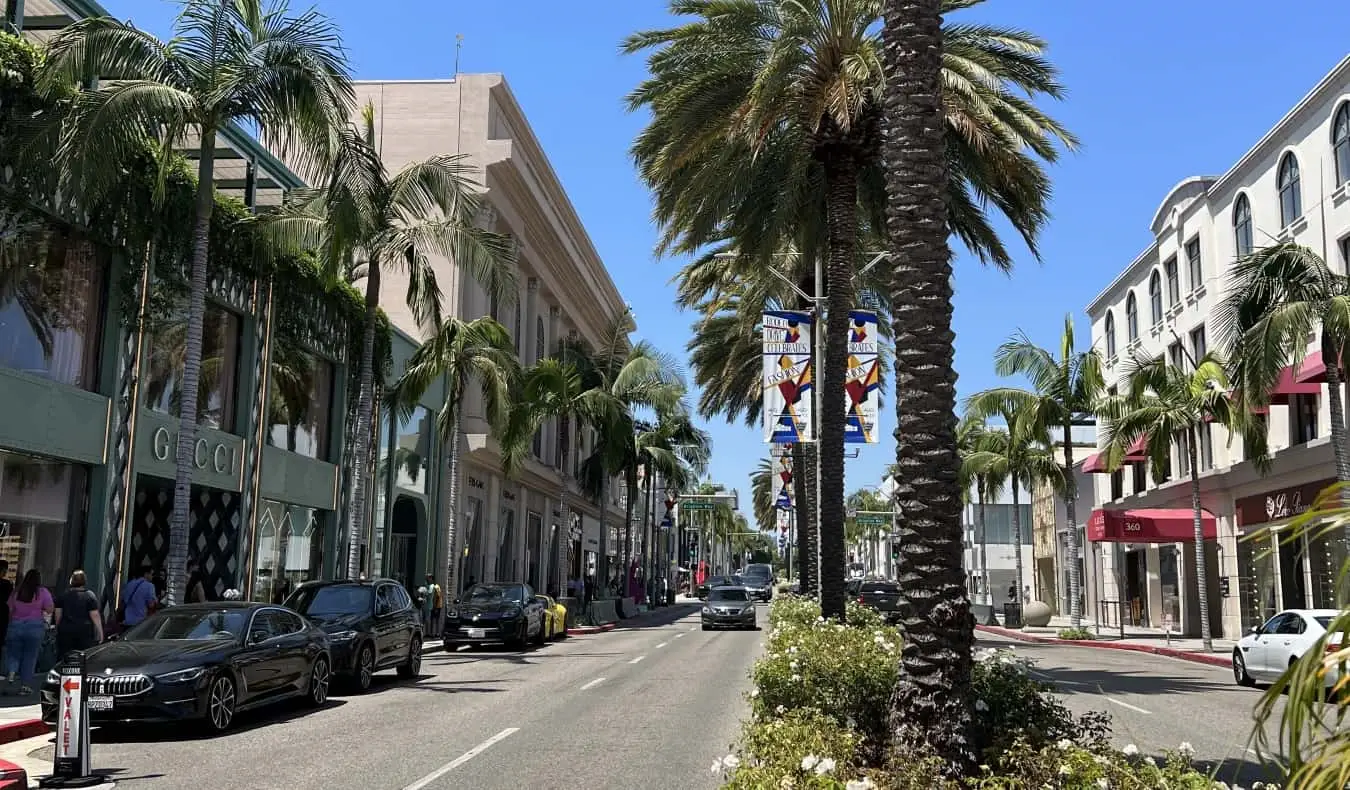 Carrer de Los Angeles ple de palmeres i botigues cares