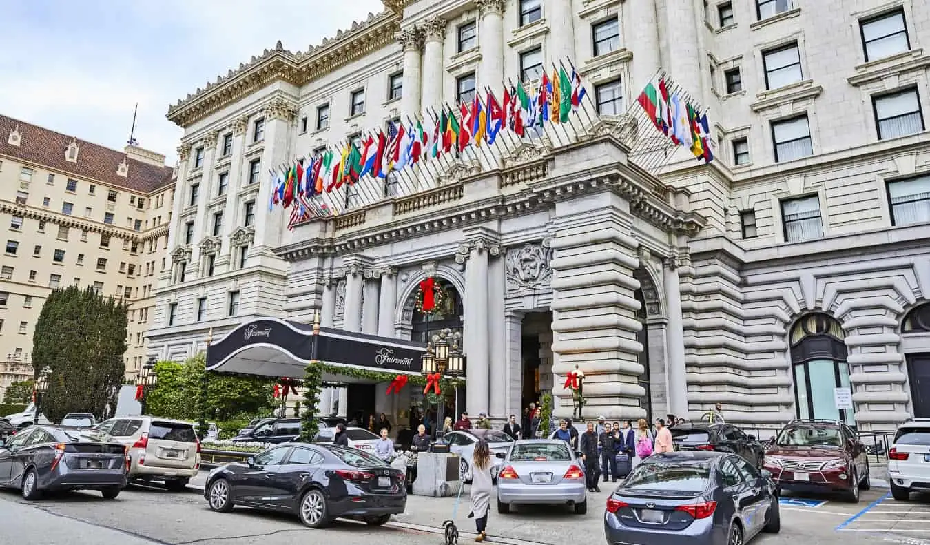 Das stattliche Fairmont Hotel in Nob Hill, San Francisco, mit Dutzenden wehenden Landesflaggen und geparkten Luxusautos davor