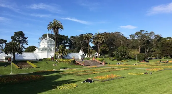 Foto cantik Taman Golden Gate pada hari yang cerah menunjukkan kehijauan yang subur dan bangunan berkubah putih