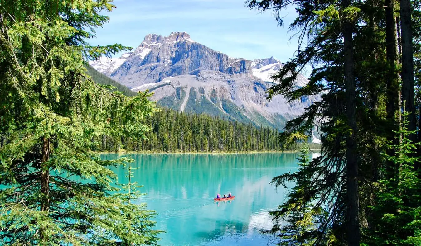 Människor som paddlar kanot på det ljusa, klara vattnet i Lake Louise, Alberta, Kanada