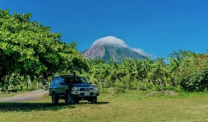 大きな山の近くの日陰に駐車されたトラック