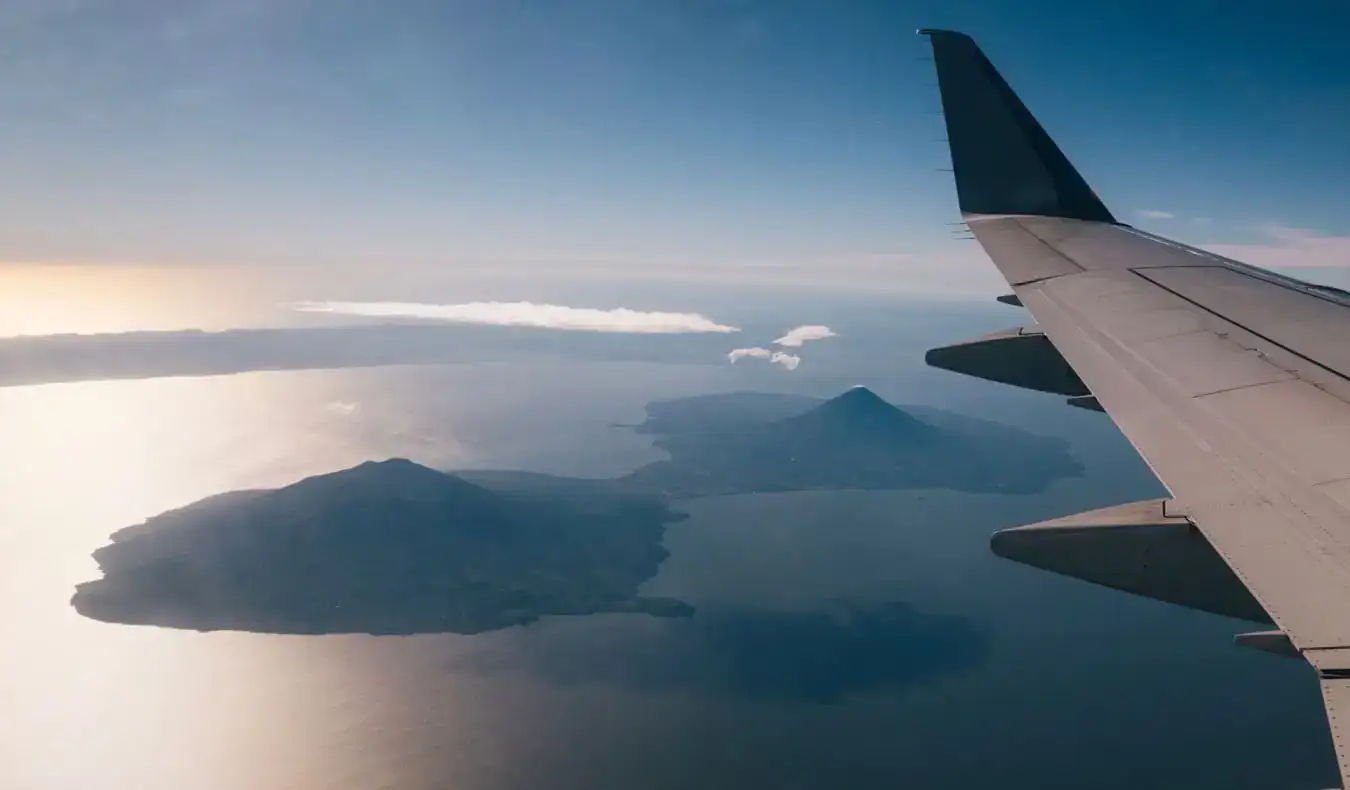 中米の青空を背景に離陸する飛行機