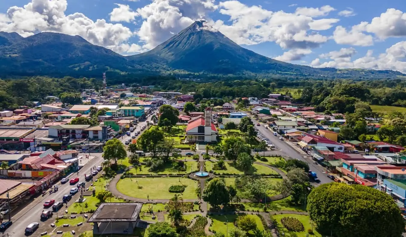 Vedere aeriană a orașului La Fortuna cu vulcanul Arenal în fundal într-o zi însorită în Costa Rica