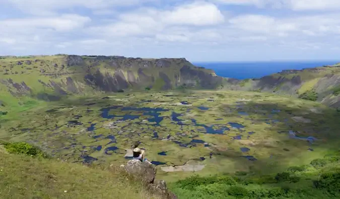 voyageur assis et regardant le paysage immaculé de l'île de Pâques