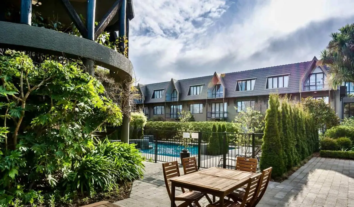 Un coin salon extérieur relaxant près de la piscine dans un hôtel de Christchurch, en Nouvelle-Zélande