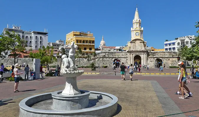 oameni care se plimbă în jurul unei piețe cu o fântână din Cartagena, Columbia