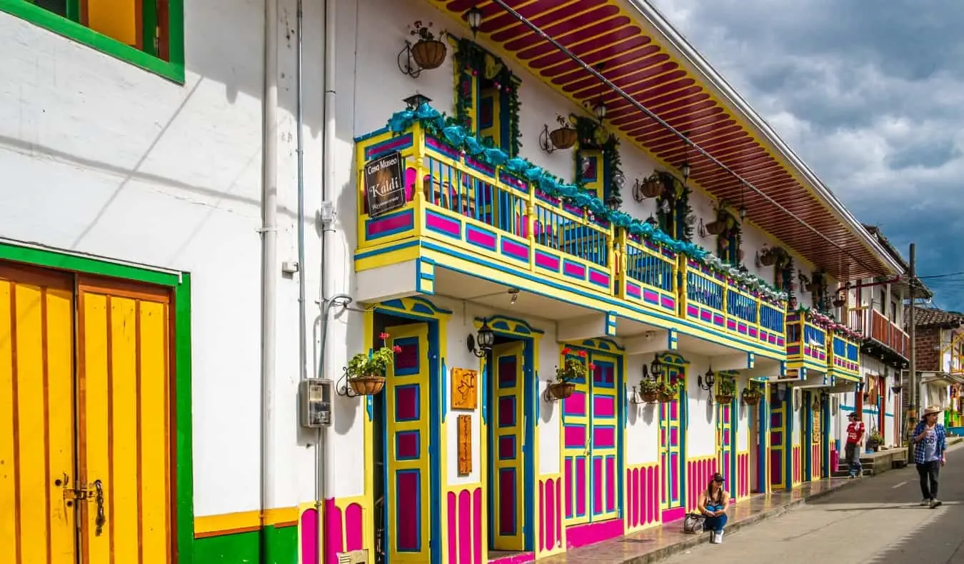 jalan terang di Salento, Kolombia dengan pintu dicat kuning, merah muda, dan biru