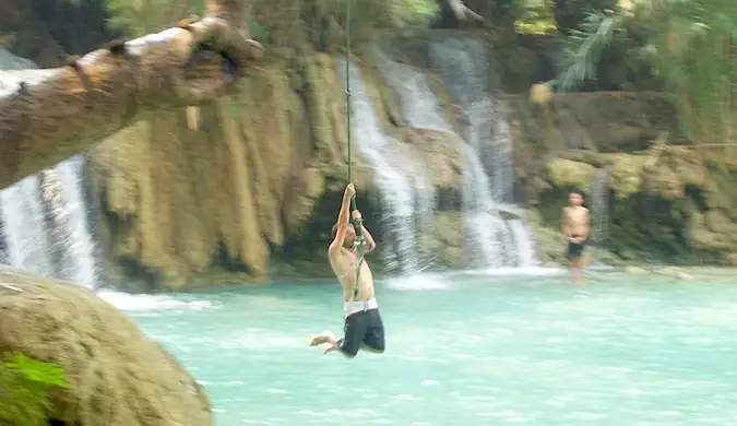 Dan Slater che si dondola nell'acqua con una corda in Asia