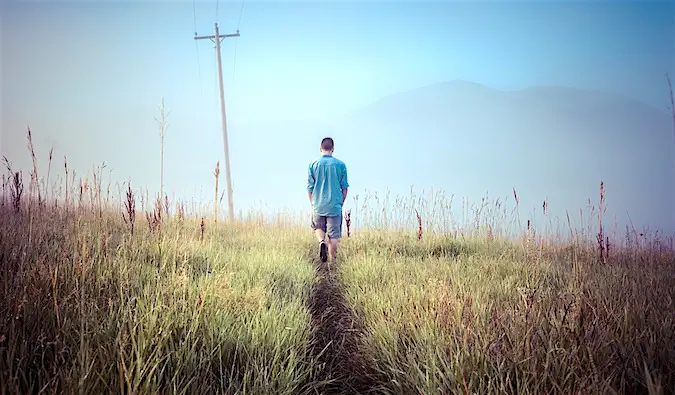 Un hombre solitario caminando por un campo vacío.